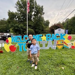 Two brothers at the Welcome Back to AIA sign