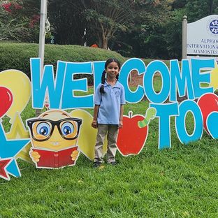 A student at the Welcome Back to AIA sign