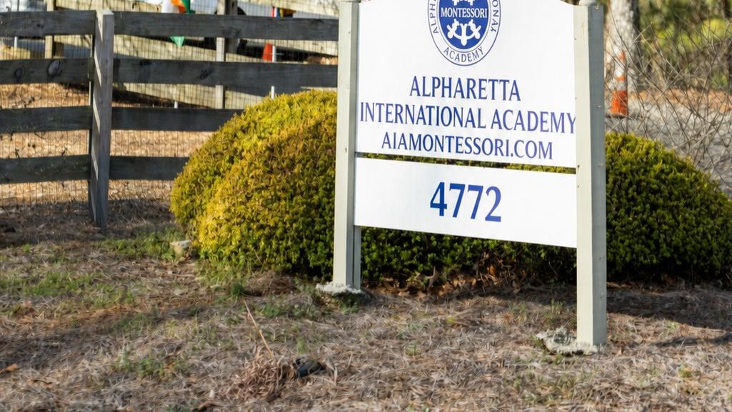 The Alpharetta International Academy entrance sign with the American flag and international flags