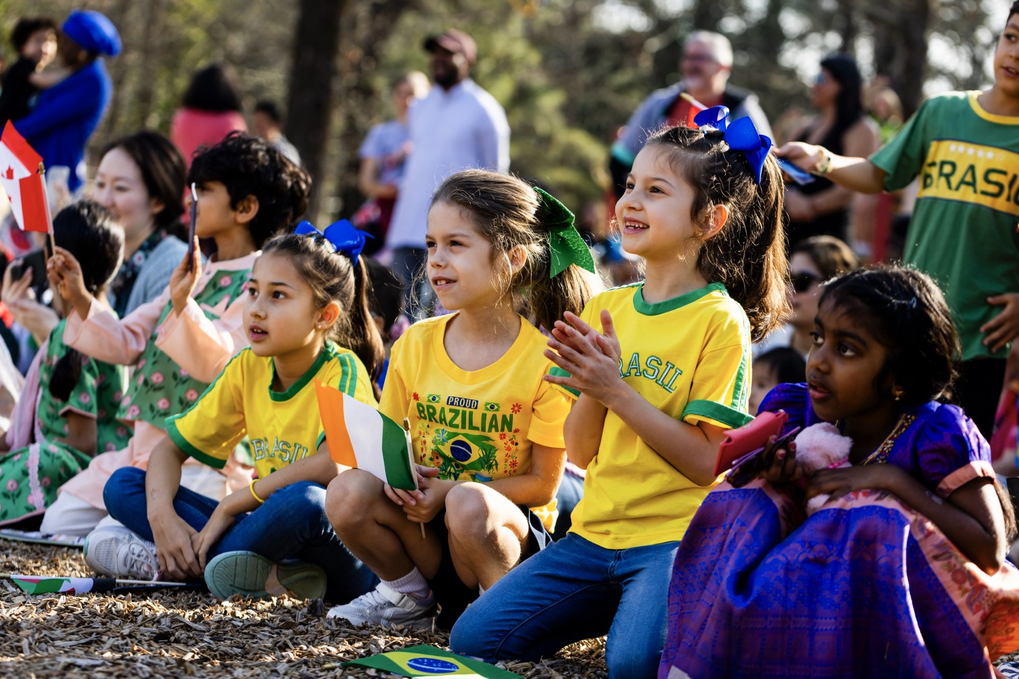 Students wearing national team jerseys and holding flags at AIA's International Day Festival