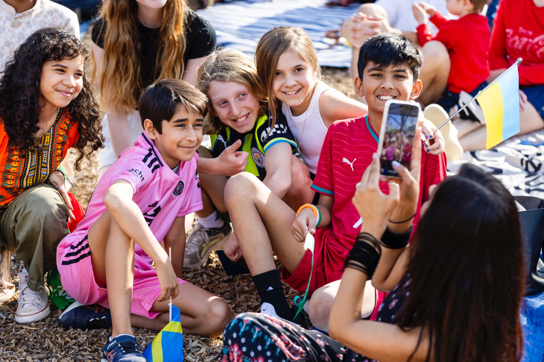 Elementary students posing together with flags at International Day