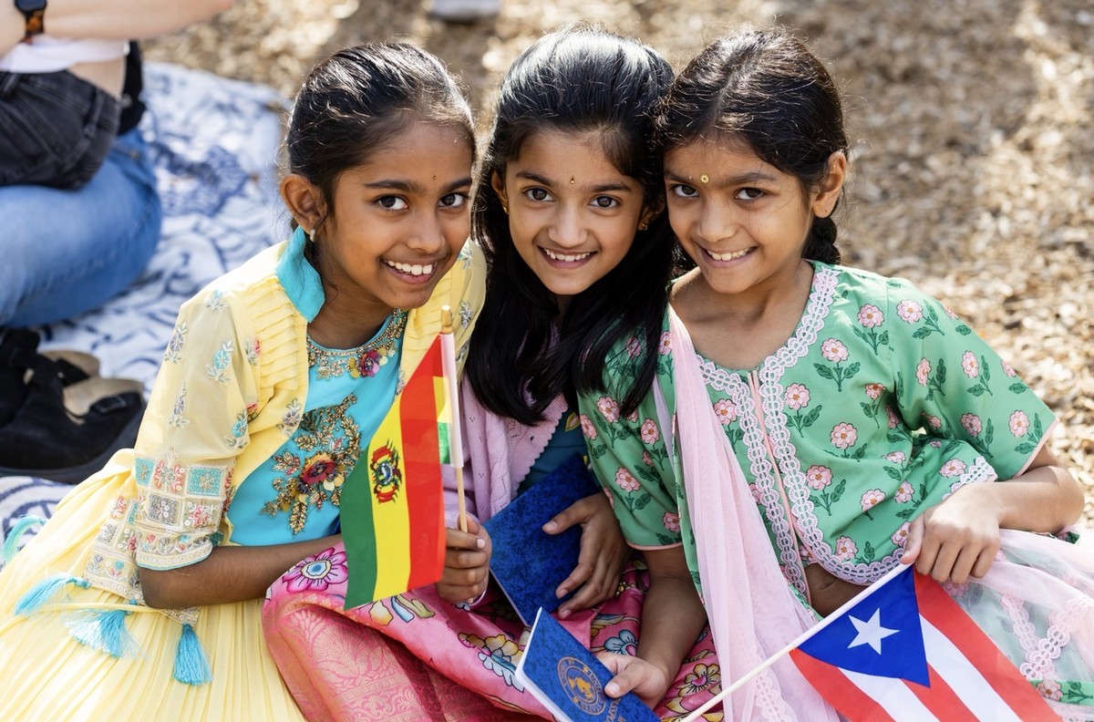 Students holding flags representing countries at International Day