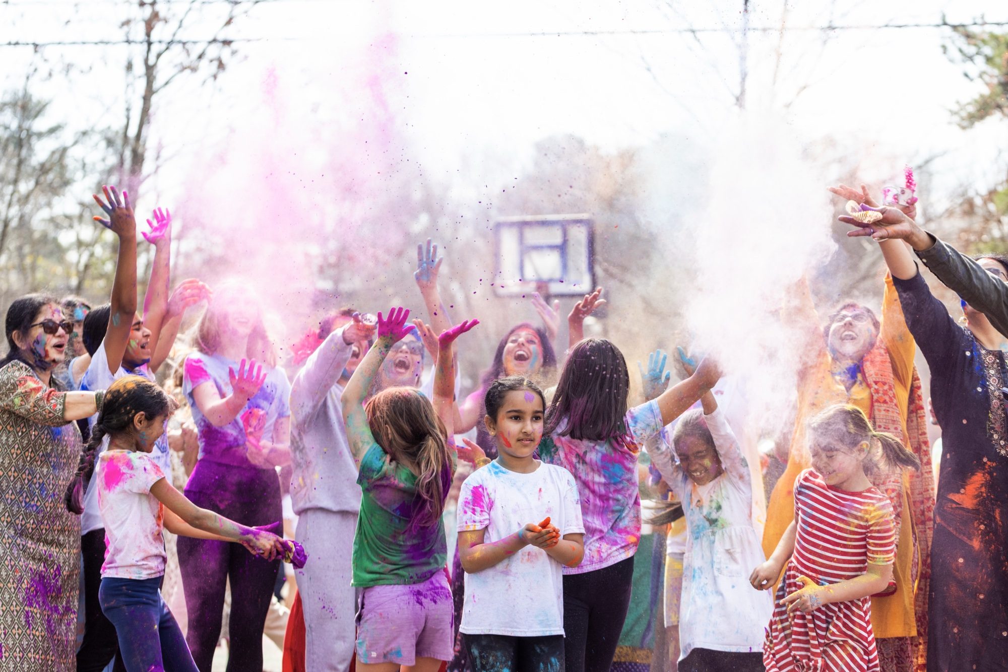 Students and families tossing colored powder together at AIA's International Day Festival