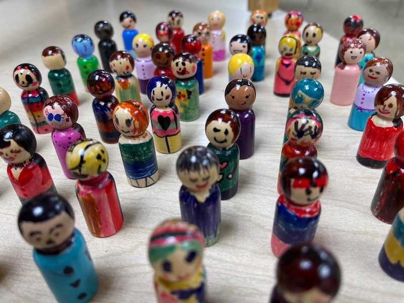 Dozens of peg dolls painted by AIA students, each one different
