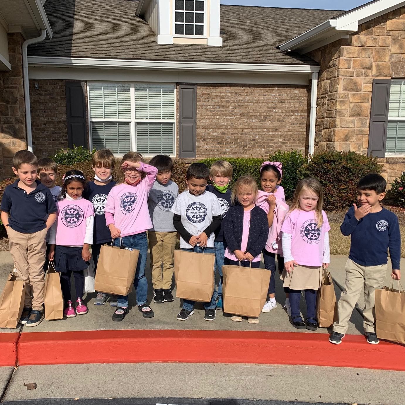 AIA students holding donation bags, ready to give back to the community